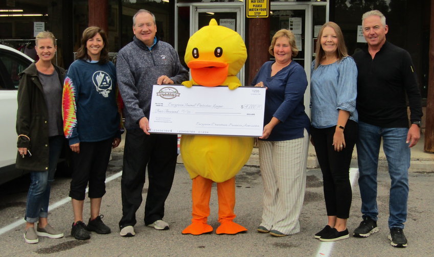 Attending the check ceremony were, from left, Chelsea Treinen and Megan Mitchell, members of the Evergreen Downtown Business Association board, Jim Wales, president of the board, the Dam Ducky Derby mascot, Bambi Moss and Patti McLaughlin, board members for the Evergreen Animal Protective League, and Bryan McFarland, an EDBA board member.